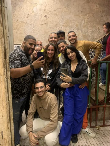 Marouane entouré d'amis et de voyageurs dans une cage d'escalier, tous souriants